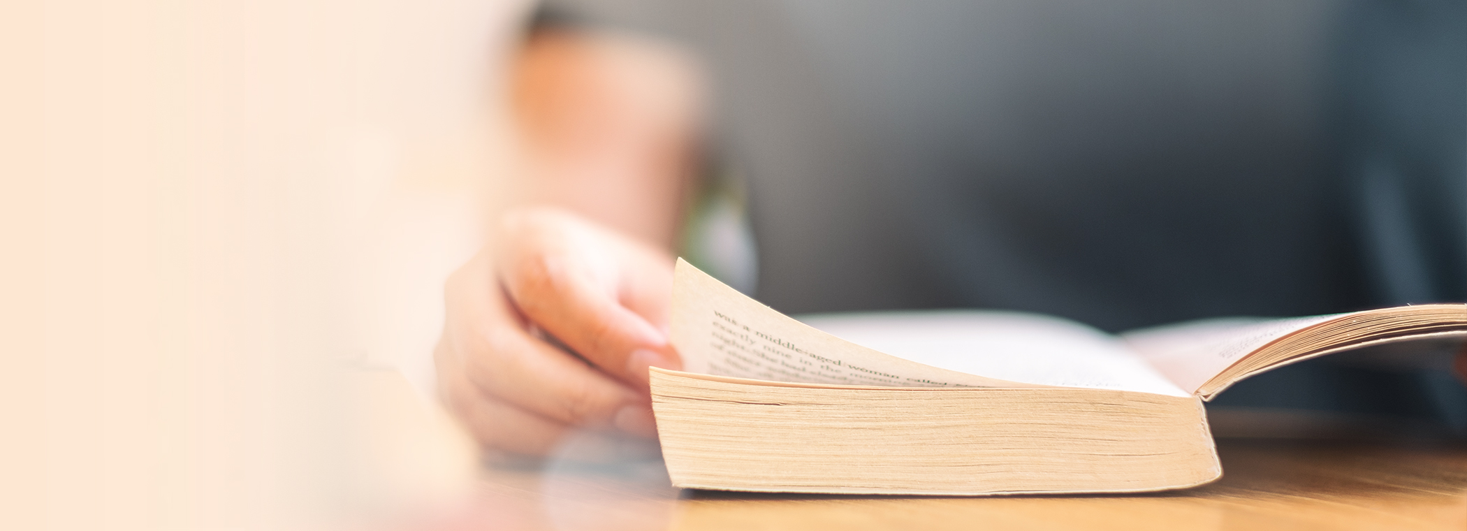 Reading a well-thumbed book at a desk